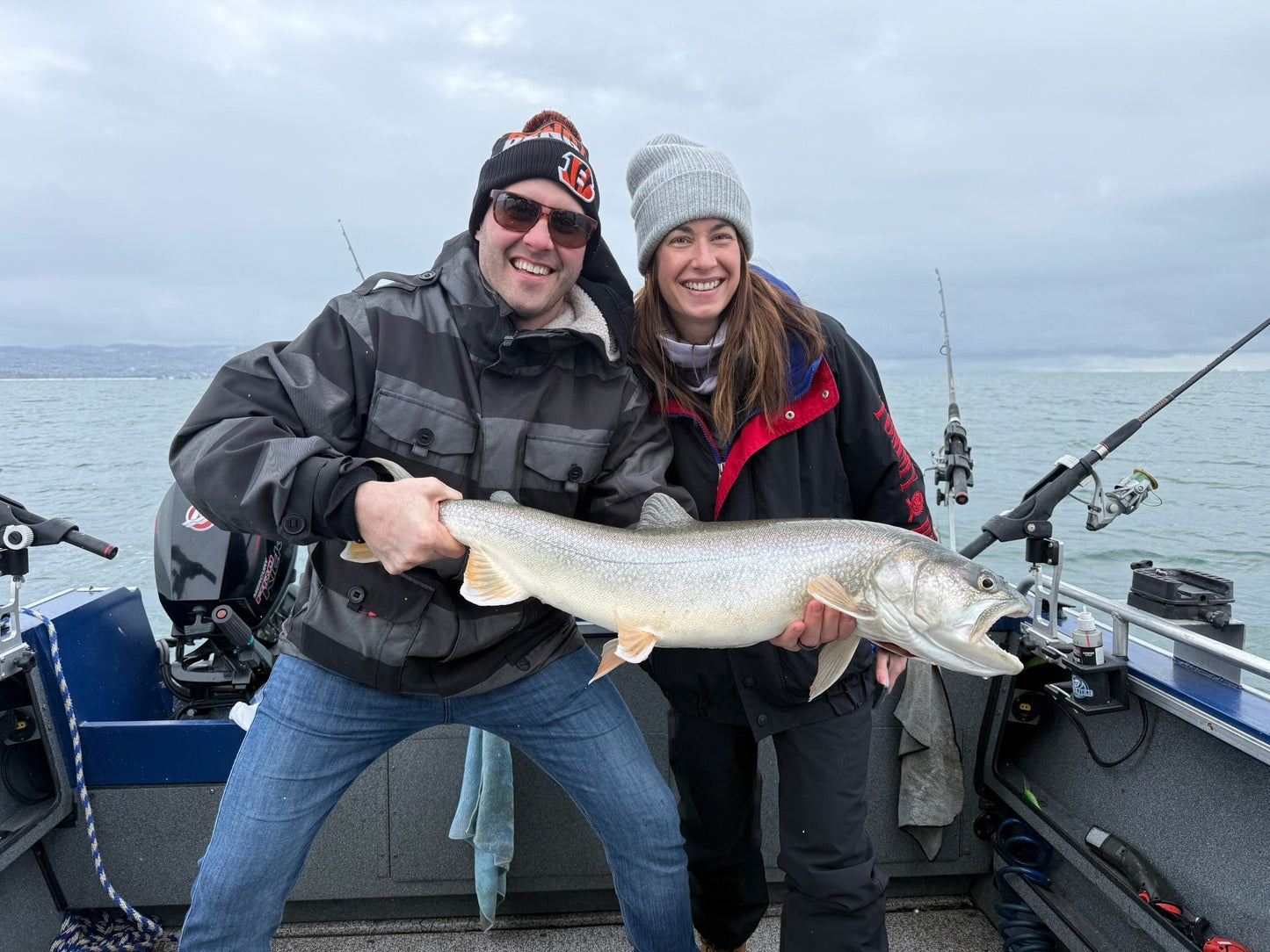 Couple holding big lake trout smiling