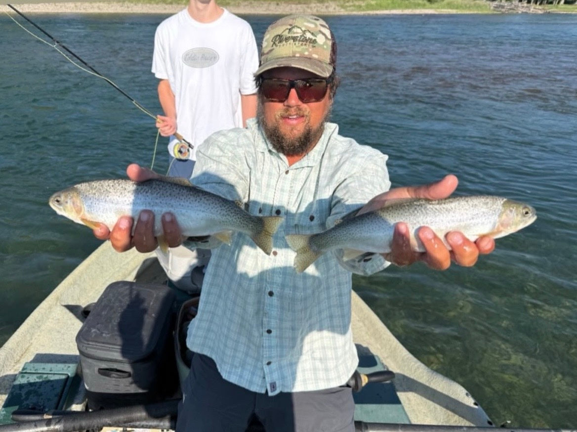 Riverstone Outfitters guide holding a double catch of rainbow trout with a teenage angler in the background